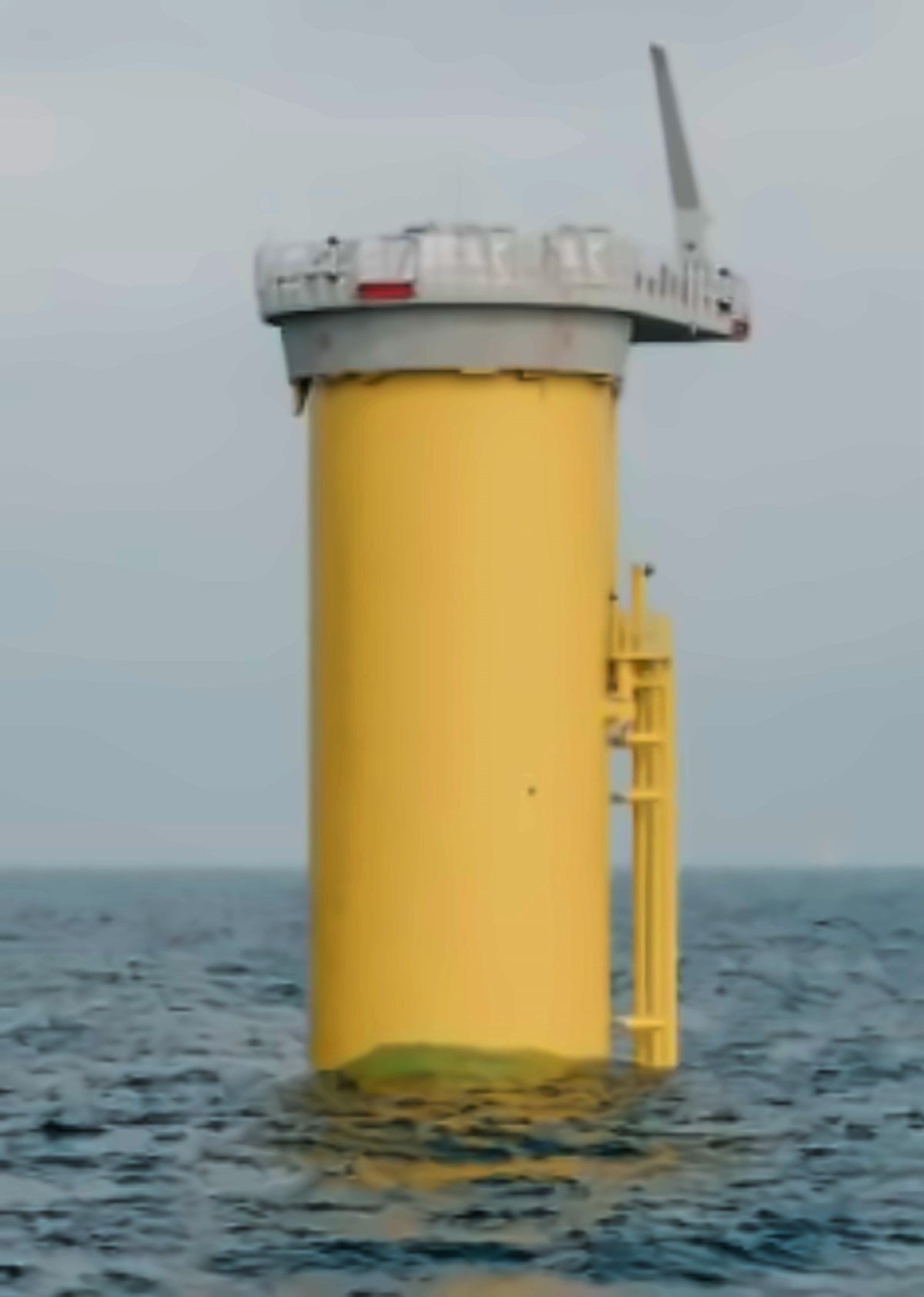 Yellow monopile foundation standing in the sea